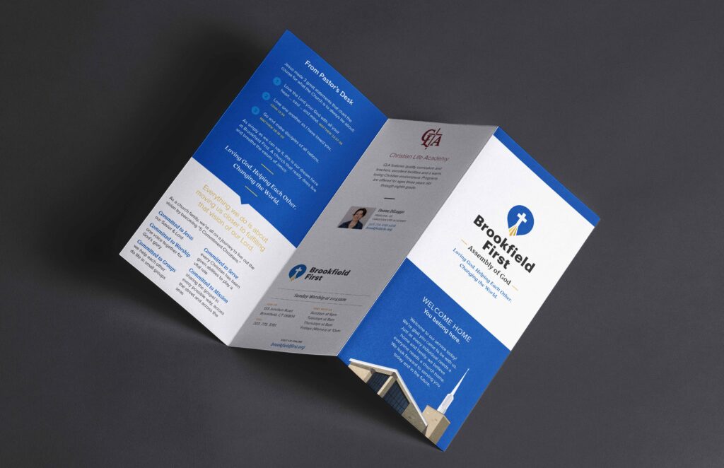 A tri-fold brochure is open on a dark background. It features a blue and white design with church imagery and text, conveying a welcoming tone.